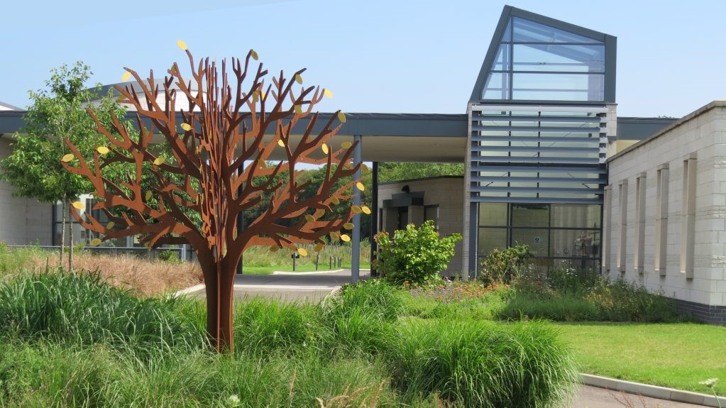 Poppies next to the steel tree of life